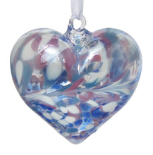 Load image into Gallery viewer, A mouth-blown glass heart-shaped decoration with an iridescent finish in blue, pink, and white colors, hanging from a white satin ribbon.
