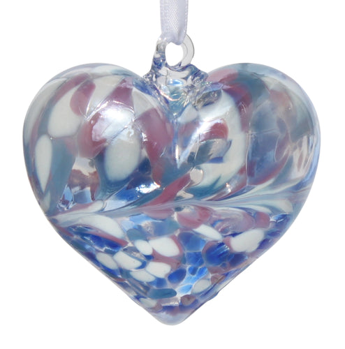 A mouth-blown glass heart-shaped decoration with an iridescent finish in blue, pink, and white colors, hanging from a white satin ribbon.